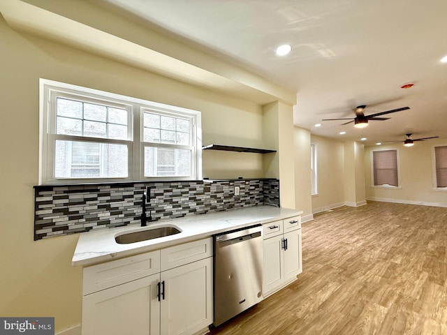 kitchen with tasteful backsplash, white cabinetry, dishwasher, and sink