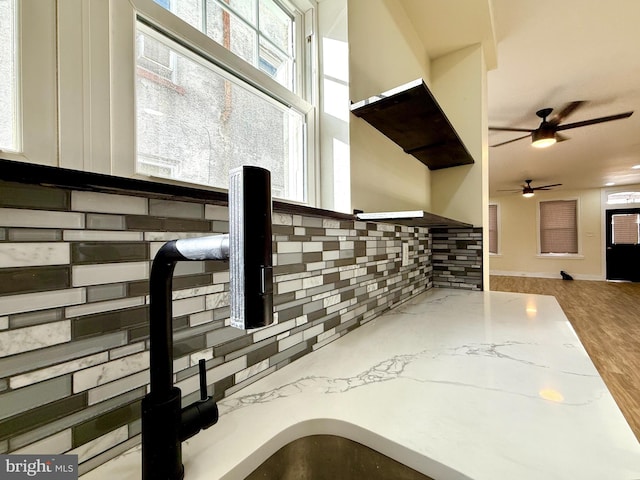 room details with ceiling fan, light stone countertops, and tasteful backsplash