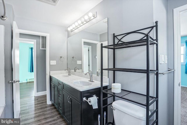 bathroom with hardwood / wood-style flooring, vanity, and toilet