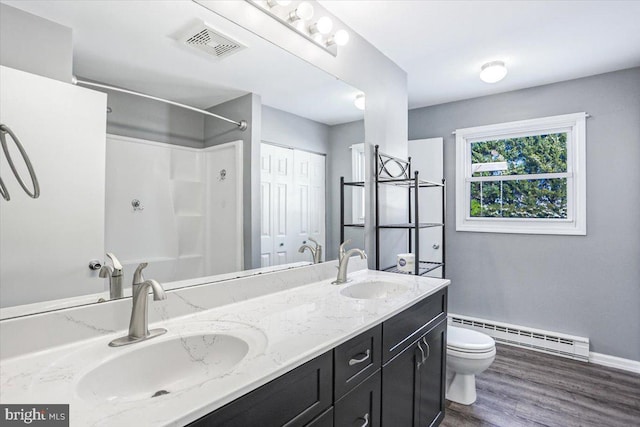 bathroom featuring walk in shower, vanity, a baseboard heating unit, wood-type flooring, and toilet