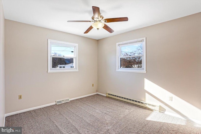 carpeted empty room with baseboard heating, ceiling fan, and plenty of natural light