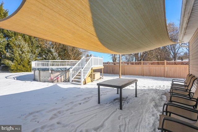 snow covered patio with a pool side deck