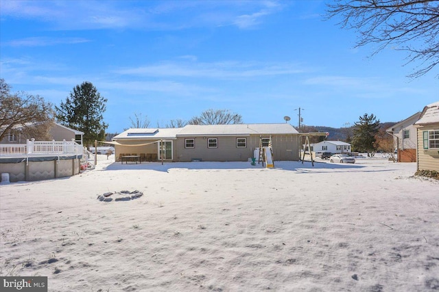 snow covered house with a covered pool