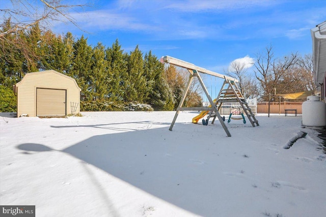 yard covered in snow featuring a playground