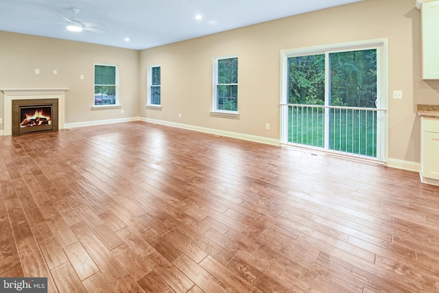 unfurnished living room with ceiling fan and light hardwood / wood-style floors