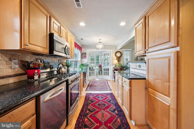 136 Sandpiper Ln, West Deptford, NJ 08086 - kitchen featuring appliances with stainless steel finishes, light hardwood / wood-style flooring, decorative backsplash, and dark stone counters