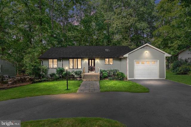 ranch-style house featuring a garage and a front lawn