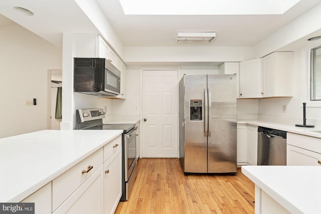 kitchen featuring white cabinetry, stainless steel appliances, and light wood-type flooring