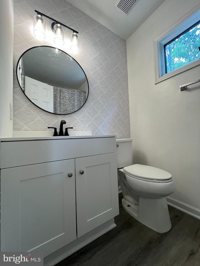 bathroom with vanity, hardwood / wood-style flooring, and toilet