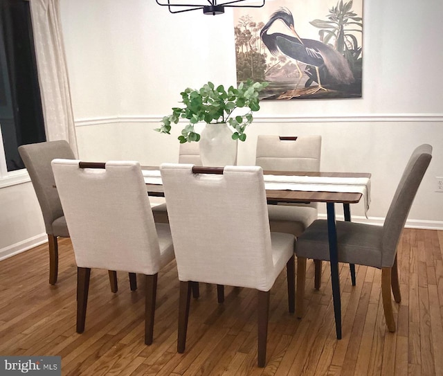 dining area featuring hardwood / wood-style flooring and a chandelier