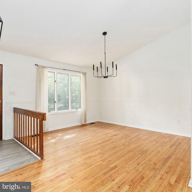 unfurnished dining area featuring a chandelier and light wood-type flooring