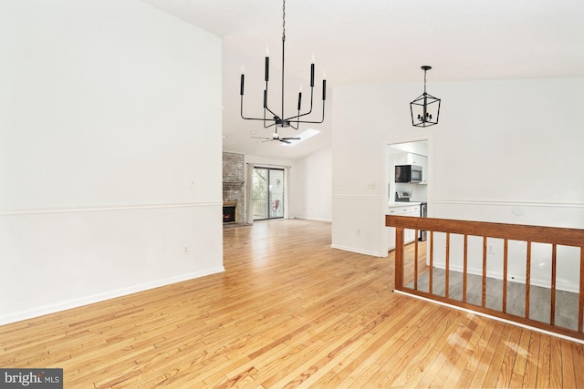 interior space featuring a fireplace, light wood-type flooring, and vaulted ceiling