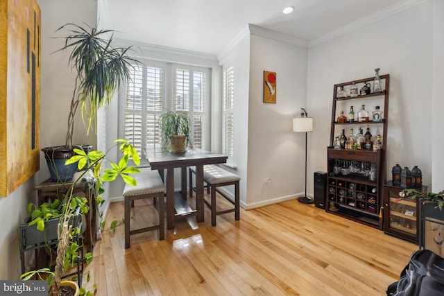 living area with crown molding and hardwood / wood-style floors