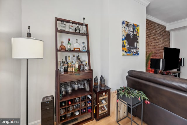 bar with light hardwood / wood-style floors and ornamental molding