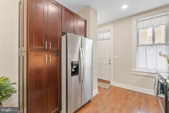 kitchen featuring stainless steel fridge and light hardwood / wood-style flooring