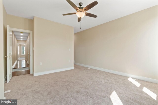 spare room with ceiling fan and light colored carpet