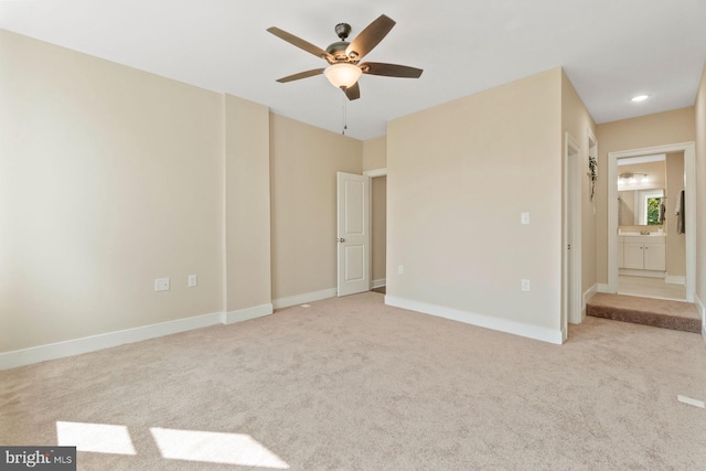 unfurnished bedroom with ceiling fan, light carpet, and ensuite bath