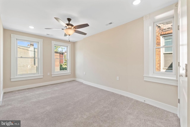 carpeted spare room featuring ceiling fan