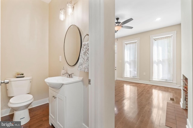 bathroom featuring hardwood / wood-style floors, toilet, plenty of natural light, and ceiling fan