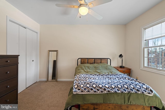 carpeted bedroom featuring ceiling fan and a closet