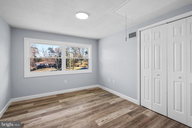 unfurnished bedroom with hardwood / wood-style floors and a closet