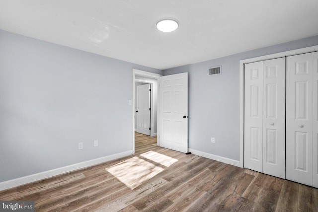 unfurnished bedroom with hardwood / wood-style floors and a closet