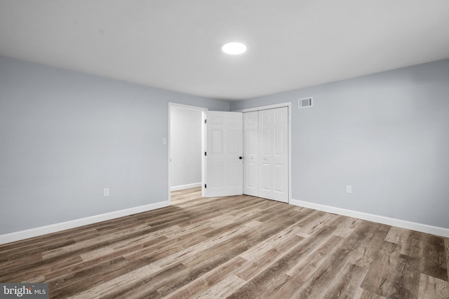 unfurnished bedroom featuring a closet and wood-type flooring