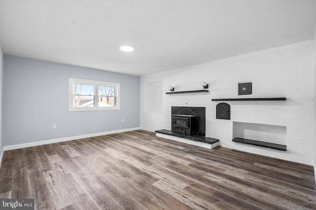 unfurnished living room featuring hardwood / wood-style floors and a wood stove