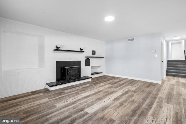 unfurnished living room with a wood stove and hardwood / wood-style floors