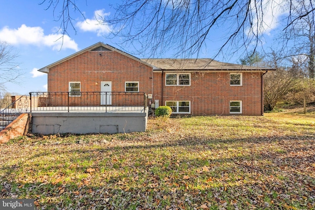 rear view of property featuring a lawn