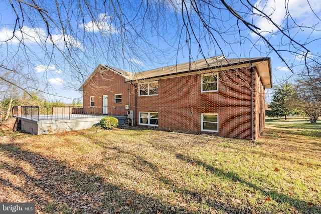 rear view of property featuring a lawn