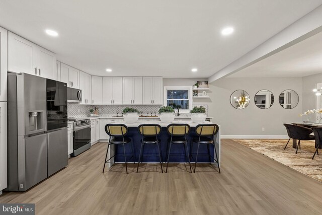 kitchen featuring appliances with stainless steel finishes, light wood-type flooring, and white cabinetry