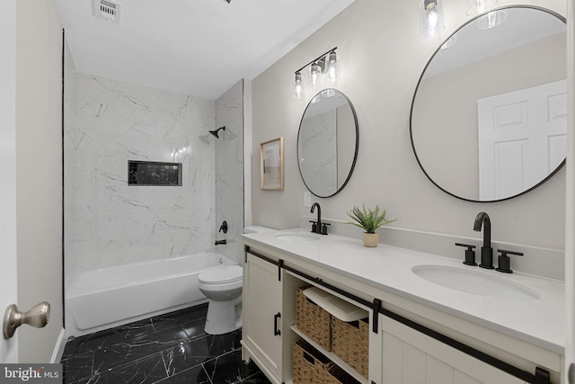 full bathroom featuring vanity, tiled shower / bath combo, and toilet