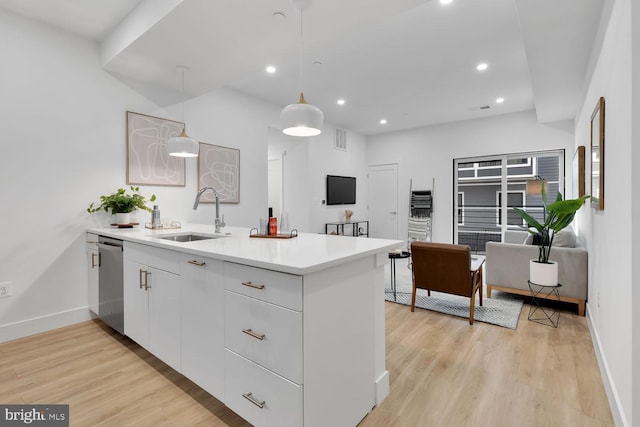 kitchen with light wood-type flooring, sink, decorative light fixtures, dishwasher, and white cabinets