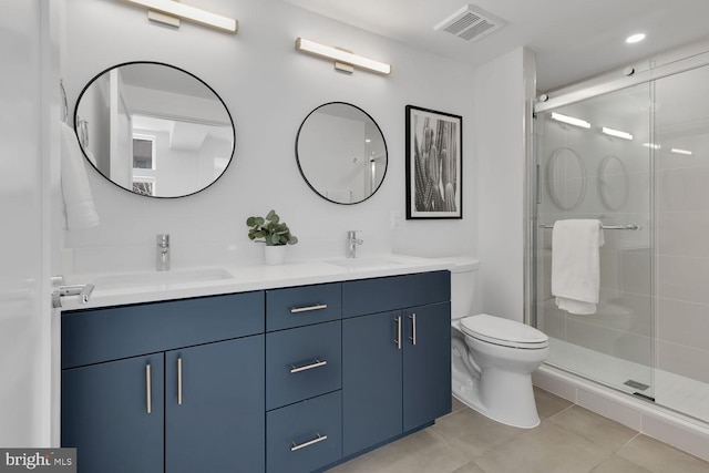 bathroom with tile patterned flooring, vanity, toilet, and a shower with shower door