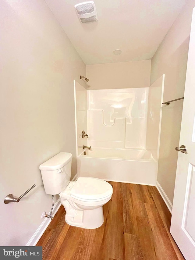 bathroom featuring shower / tub combination, hardwood / wood-style flooring, and toilet