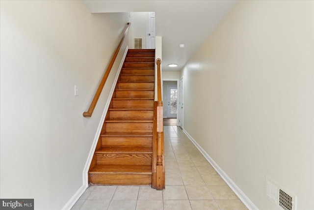 stairway with tile patterned floors