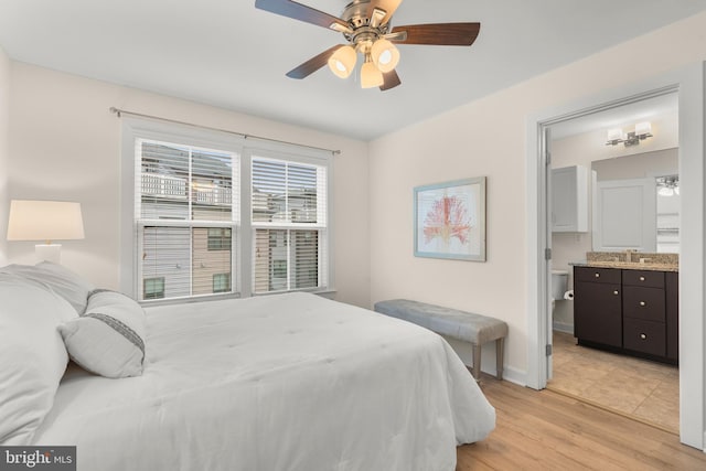 bedroom with ceiling fan, ensuite bathroom, and light hardwood / wood-style flooring