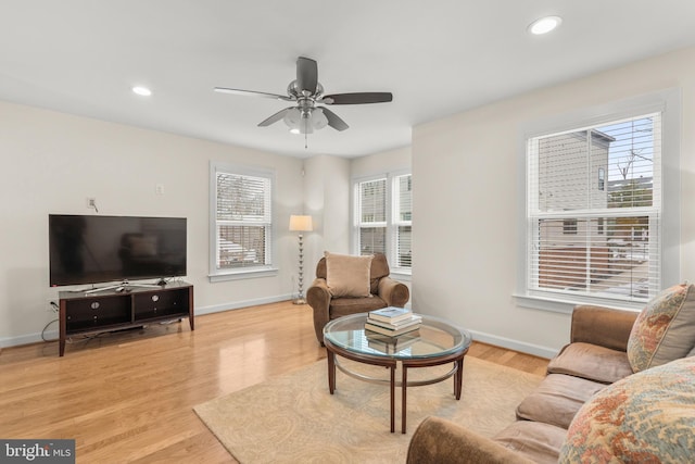 living room featuring ceiling fan, plenty of natural light, and light hardwood / wood-style floors