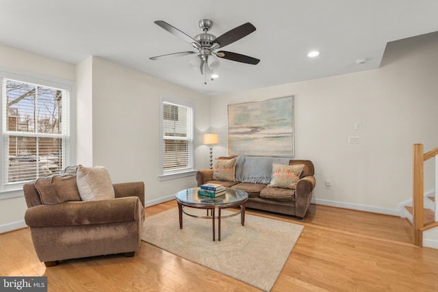 living room with ceiling fan and light hardwood / wood-style flooring