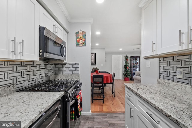 kitchen with dark hardwood / wood-style floors, white cabinetry, and stainless steel appliances