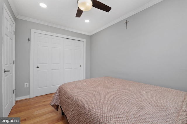 bedroom featuring a closet, crown molding, ceiling fan, and light hardwood / wood-style floors