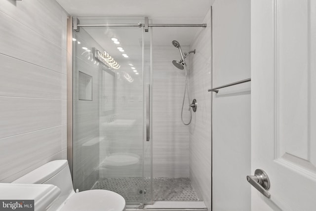 bathroom with an enclosed shower and toilet