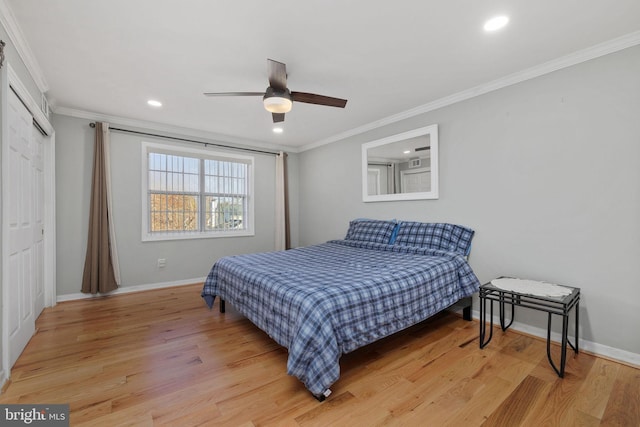 bedroom with ceiling fan, light wood-type flooring, ornamental molding, and a closet