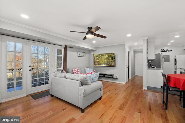 living room with ceiling fan, ornamental molding, and light hardwood / wood-style flooring