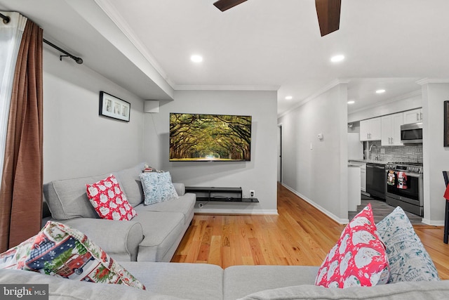 living room featuring light wood-type flooring and crown molding