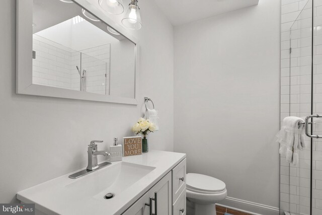 bathroom with vanity, toilet, and a shower with door