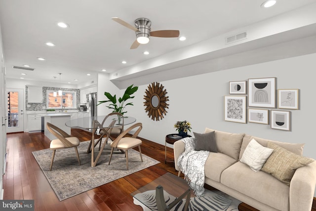 living room featuring dark hardwood / wood-style flooring, ceiling fan, and sink