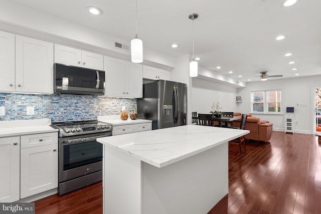 kitchen featuring white cabinets, ceiling fan, pendant lighting, and stainless steel appliances