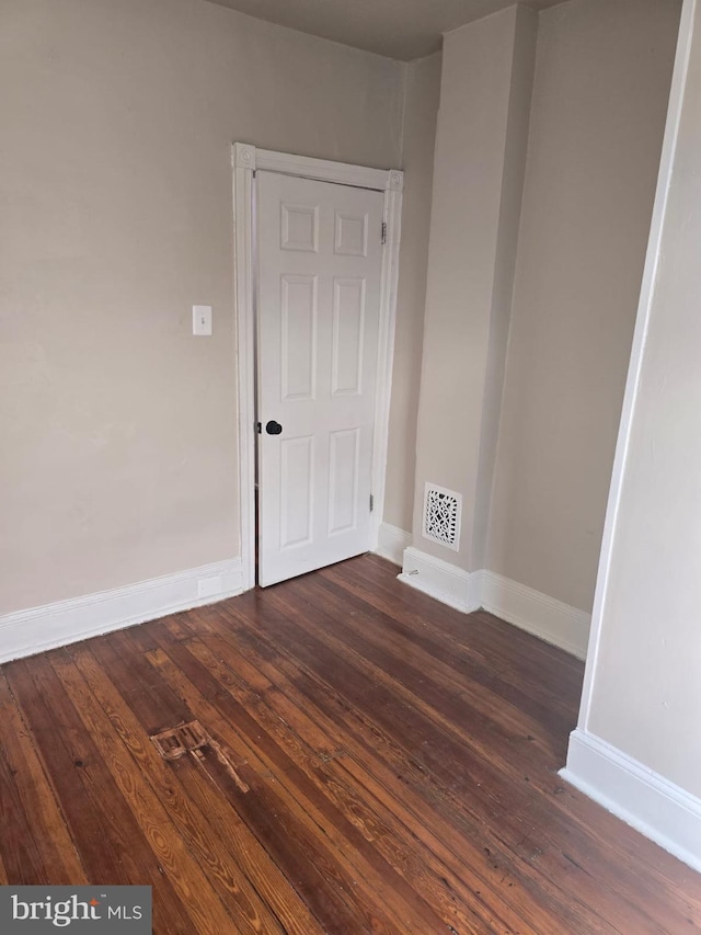 unfurnished room with dark hardwood / wood-style flooring